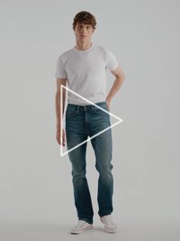 Camiseta blanca ajustada combinada con vaqueros azul medio. Los vaqueros tienen una textura ligeramente desgastada y un diseño de pierna recta. Zapatillas blancas con detalles en rojo.