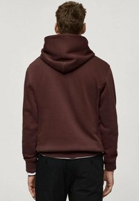 Bordový mikina s velkou kapucí na tkaničku. Vyrobena z měkké tkaniny s texturovaným vzhledem, s žebrovanými manžetami a spodním lemem.