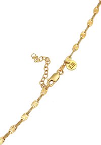 Gold-tone chain bracelet with circular links featuring a patterned design. It includes a lobster clasp and adjustment chain with a metal tag.