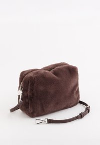 Bruine pluche handtas met een zachte, pluizige textuur; voorzien van een zilveren ritssluiting, stervormige bedel en een afneembare bruine leren riem.