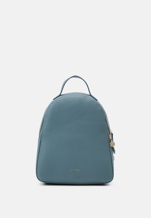 Sac à dos compact en cuir bleu avec poignée supérieure, fermeture éclair dorée et petit logo centré près du bas du panneau avant.