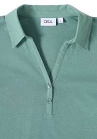 Groene poloshirt gemaakt van gladde stof, met een knoopsluiting, een kraag en korte mouwen. Etiket zegt "CECIL," maat "S."