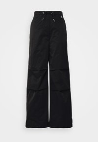 Pantalon noir à jambes larges avec taille à cordon et logo discret en haut à gauche, présenté sur fond blanc.