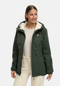 Dark green, padded jacket with a zip and drawstring hood, featuring a soft cream lining and side pockets. Adjustable cuffs complete the design.