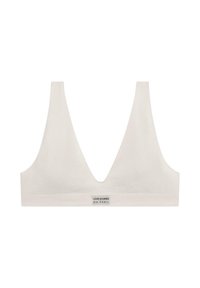 Ribbad vit bralette med djup V-ringning och breda axelremmar. Har en liten etikett vid basen. Mjuk, stretchningsbar tyg.