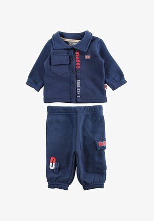 Ensemble en polaire bleu marine comprenant un haut boutonné à manches longues avec une poche poitrine et un logo. Pantalon en polaire assorti avec poche latérale.