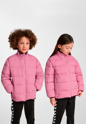 Chaquetas acolchadas de color rosa claro con cierre de cremallera, cuello alto y costuras horizontales, usadas sobre pantalones negros con franjas blancas.