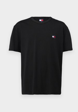 T-shirt noir à manches courtes col rond avec petit logo Tommy Jeans rouge, blanc et bleu sur le côté gauche de la poitrine.