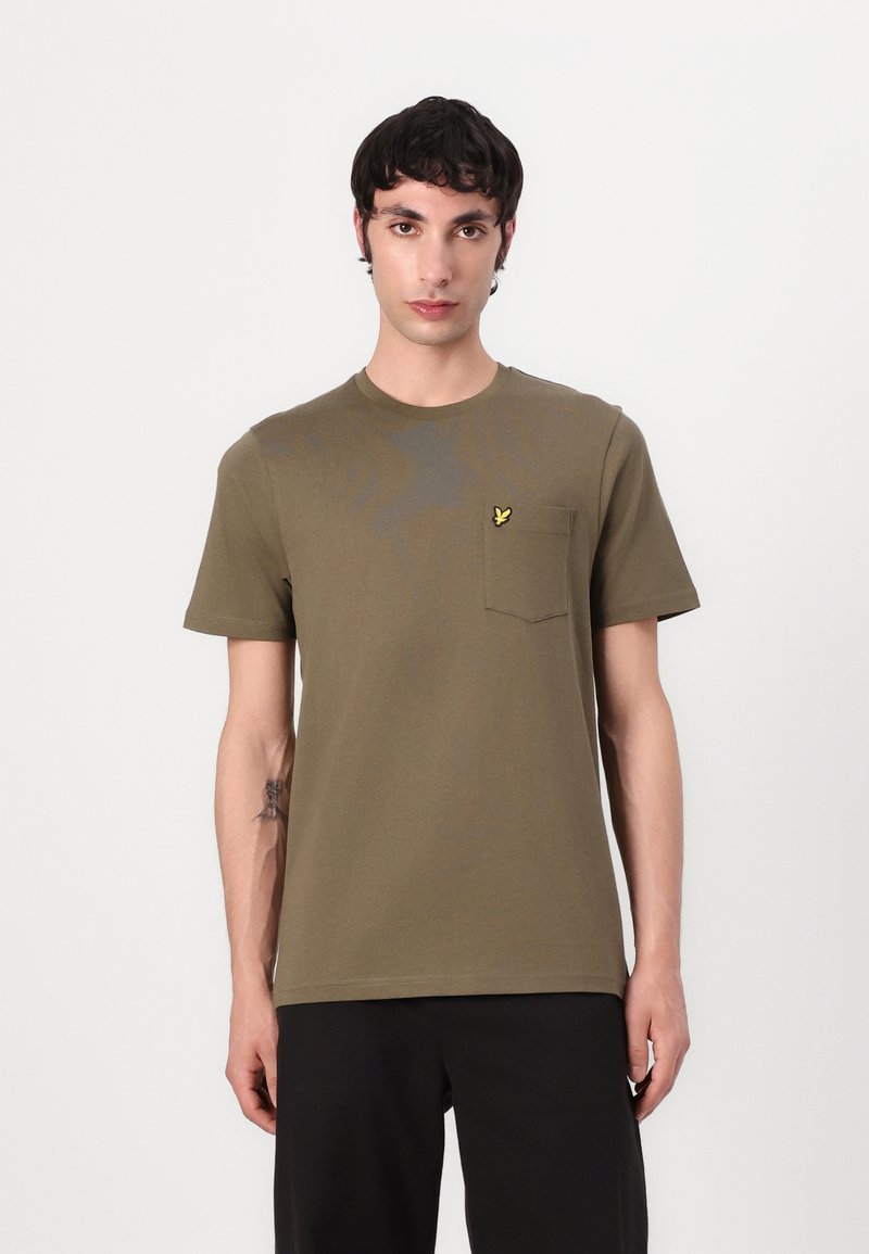 Tricou din bumbac verde măslinie cu mâneci scurte, decolteu rotund și buzunar pe pieptul stâng cu un logo brodat galben. Finisaj texturat.