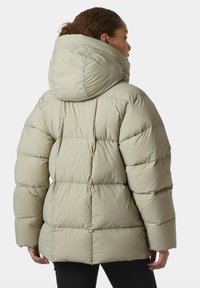 Giacca puffer beige chiaro con un ampio cappuccio, design trapuntato e texture morbida. Presenta maniche oversize e una vestibilità rilassata.