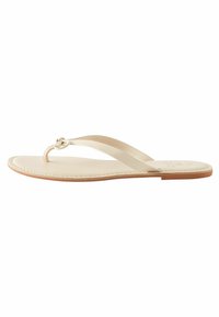 Beige flip-flop sandaalit, joissa on kaksi ohutta remmiä, keskuslenkki ja litteä nahkapohja vaaleanruskealla reunalla.