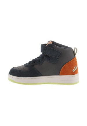 Hoge sneaker van donkerblauw suède en leer. Heeft een bruin suède accent, klittenbandsluiting, grijze tong en lichtgroene zool.