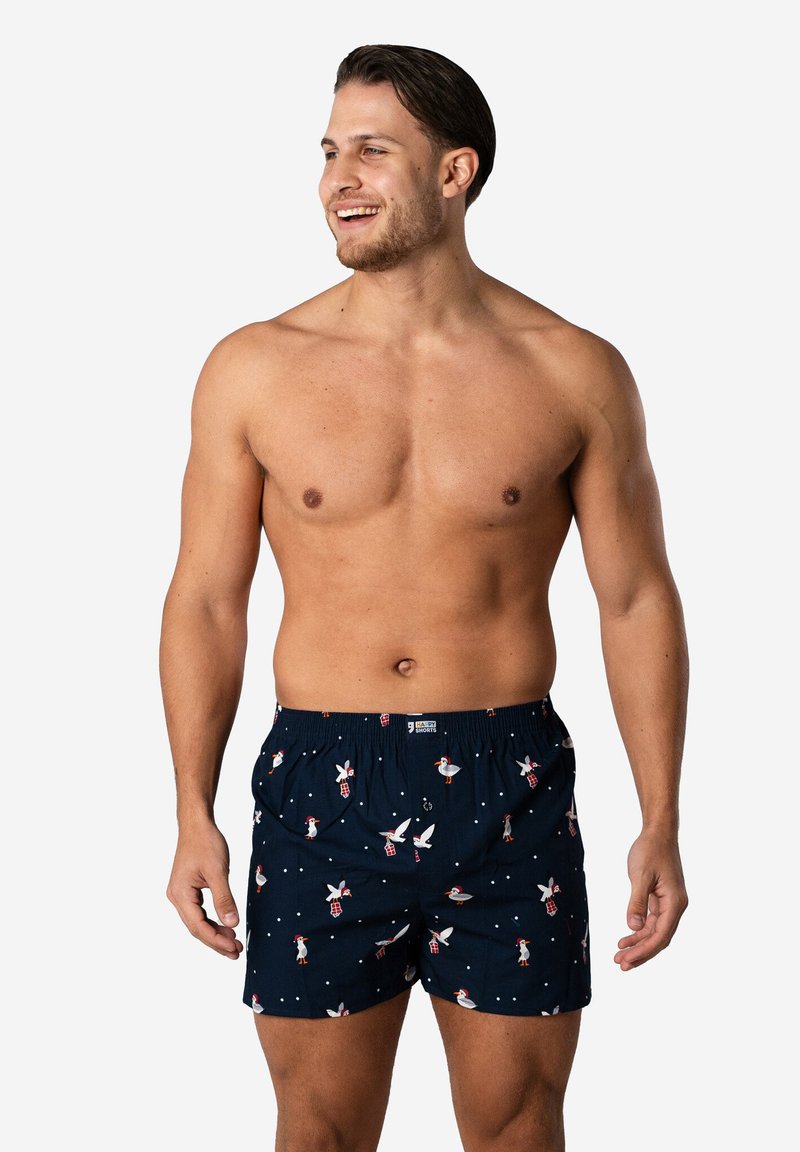 Marineblauwe korte zwembroek met een elastische tailleband, versierd met een patroon van eenden en molens, gemaakt van lichtgewicht stof.