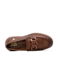 Zapato slip-on de cuero marrón con un acento de cadena gruesa en la parte frontal, con una suela texturizada y un diseño suave y redondeado.