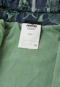 Giacca per bambini Reima con rivestimento in pile verde e un esterno impermeabile blu navy con motivo floreale e dettagli riflettenti.