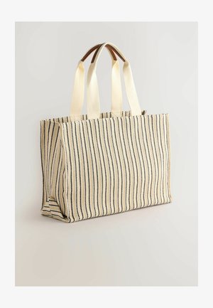 Rectangular tote bag in beige with black vertical stripes. Features sturdy fabric, two fabric handles, and a spacious interior with no visible hardware.
