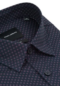 Ciemnobłękitna koszula męska z małym różowym wzorem kwiatowym, zapinana pod szyją, z widoczną metką markową wewnątrz kołnierza.