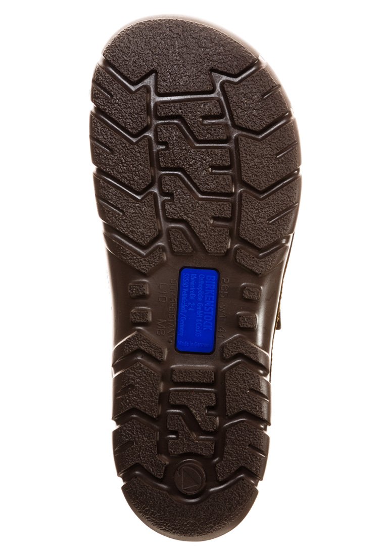 Brown rubber shoe sole with textured tread pattern, featuring a blue label and an embossed logo. Designed for durability and traction.