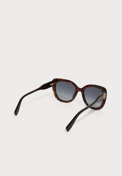 Gafas de sol de montura cuadrada de carey con lentes oscuros de degradado y patillas delgadas en negro, sobre un fondo claro y liso.