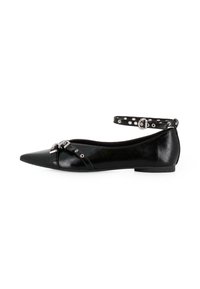 Zapato plano negro con punta afilada, acabado brillante y tira al tobillo con detalles de tachuelas plateadas y hebilla. Construcción ligera.