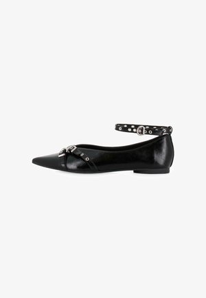 Zapato plano negro con punta afilada, acabado brillante y tira al tobillo con detalles de tachuelas plateadas y hebilla. Construcción ligera.