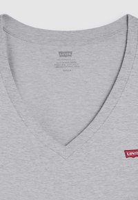 T-shirt cinza com decote em V, feita de algodão. Apresenta um pequeno logótipo vermelho da Levi's no lado esquerdo. Textura suave, design simples e mangas curtas.