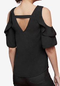 Schwarzes Top mit schulterfreien Trägern, Rüschenärmeln und einem Schlüsselaugen-Design auf der Rückseite. Glatter Stoff mit kunstvollen Nähten entlang der Kanten und Nähte.