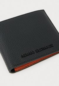 Portafoglio in pelle nera testurizzata di Armani Exchange con logo in rilievo e bordo interno arancione visibile su uno sfondo neutro.
