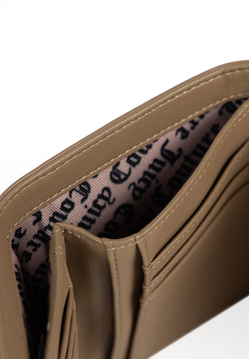 Portafoglio in pelle beige aperto, che mostra più scomparti per carte e una fodera interna in tessuto con testo stampato in nero.