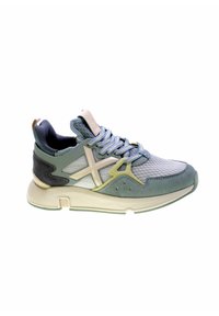 Zapatilla con parte superior de malla en azul claro y gris, con acentos de ante, suela de goma y un distintivo diseño cruzado en el costado.
