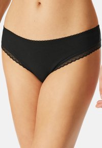 Culotte noire en coton avec une bordure en dentelle à la taille et aux ouvertures des jambes, présentant une texture lisse et une coupe taille basse.