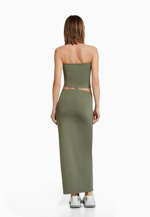 Olivgrön tvådelad outfit med en åtsittande strapless topp och en lång, figurnära kjol, tillverkad av ett mjukt och stretchigt tyg.