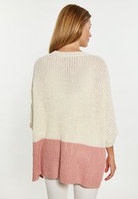 Cardigan in cotone lavorato a maglia con una vestibilità comoda, caratterizzato da una sezione superiore color crema e una sezione inferiore rosa. Le fessure sui lati migliorano la traspirabilità.