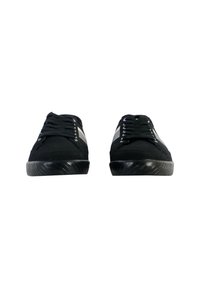 Zapatillas de ante negro con un acabado suave, que cuentan con una suela de goma, acentos blancos en los lados y cordones negros.