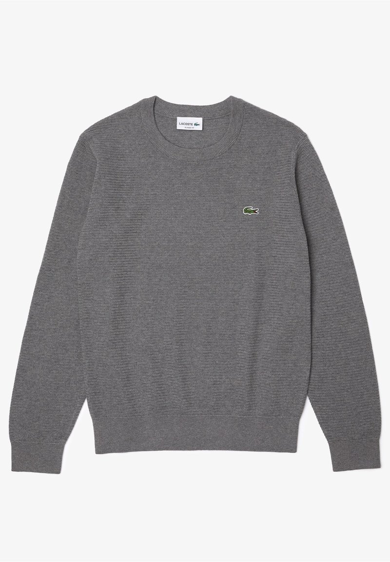 Pull gris à manches longues en tricot avec col rond et petit logo crocodile vert Lacoste à gauche sur la poitrine.