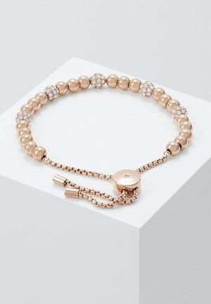 Verstelbare armband met gouden kralen en ronde, met kristallen bezette kralen, gelijkmatig verdeeld, gepresenteerd op een wit oppervlak.