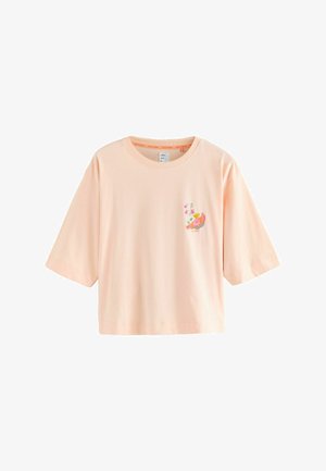 Hellpfirsichfarbenes kurzärmeliges T-Shirt mit einer kleinen bunten Vogel- und Blumenstickerei auf der linken Brustseite.