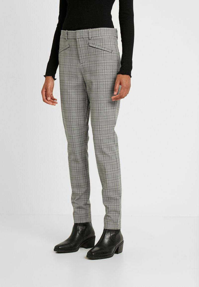 Gray plaid trousers with a slim fit. Features two front pockets and a flat waistband. Worn with black ankle boots. Smooth fabric texture.