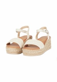 Sandali wedge bianchi con tomaia in tessuto intrecciato, cinturino alla caviglia regolabile e suola in materiale simile alla paglia con texture. Presentano una larga banda per le dita e una piattaforma.
