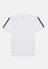 Λευκό βαμβακερό μπλουζάκι με μαύρες ρίγες στις μανσέτες. Κοντά μανίκια, κωδικός λαιμού, απλός σχεδιασμός και καθαρό φινίρισμα.