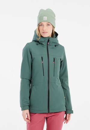 Green waterproof jacket with a fitted design, black zipper, two front pockets, and a hood; worn with a light green beanie.