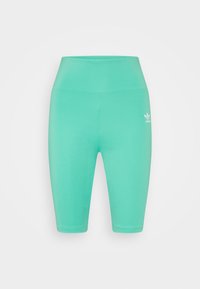 Höga turkosa Adidas cykelbyxor med en liten vit logotyp på övre vänstra låret, uppställda mot en enkel bakgrund.