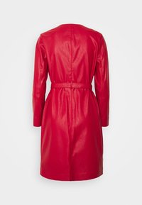 Červený kožený kabát s páskem v oblasti pasu, dlouhými rukávy a hladkou texturou. Má čistý, minimalistický design bez viditelných zapínání.