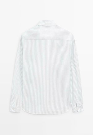 Koszula z długim rękawem z białej bawełny w jasnoniebieskie pionowe paski. Posiada standardowy kołnierz i zapięcia na guziki przy mankietach.