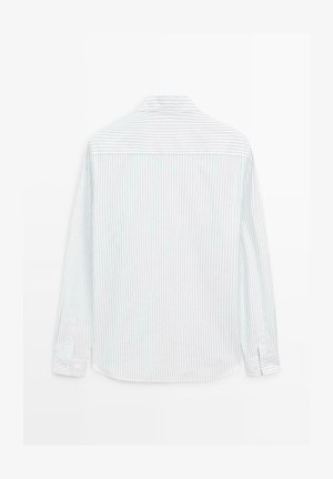 Koszula z długim rękawem z białej bawełny w jasnoniebieskie pionowe paski. Posiada standardowy kołnierz i zapięcia na guziki przy mankietach.