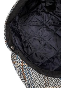 Woven wool bag with a houndstooth pattern in gray, orange, and blue. Lined with black quilted synthetic fabric and secured with a snap.