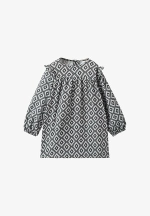 Dolga obleka v črno-beli barvi z diamantskim vzorcem, ki ima okoli ovratnika obrobo in elastične manšete. Lahka tkanina.