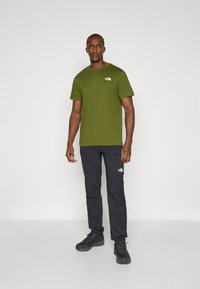 The North Face M SS BOX NSE TEE - Print T-shirt - woodland green/black