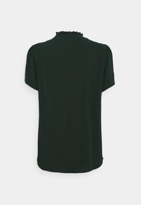 Blusa verde scuro a maniche corte con collo arricciato e una texture liscia con un motivo sottile. Vista posteriore, stile con orlo arrotondato.
