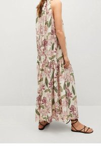 Kwiatowa sukienka maxi w odcieniach kremu z różowymi i zielonymi wzorami kwiatowymi, z halter neck, wielowarstwowym krojem i luźnym fasonem. Połączona z brązowymi sandałami.